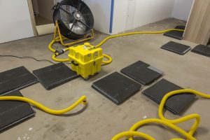 Fan and drying equipment in a basement while waiting for foundation repair in Edmonton